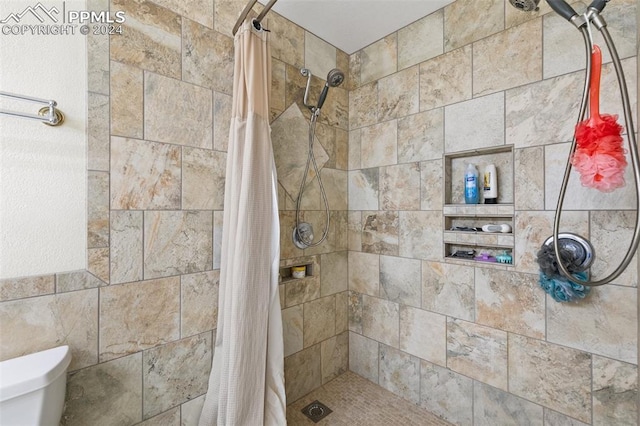 bathroom with curtained shower, toilet, and tile walls