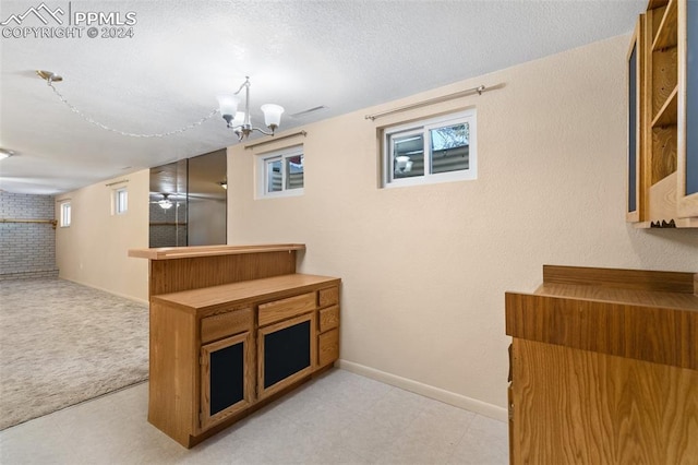 kitchen featuring a chandelier and a textured ceiling