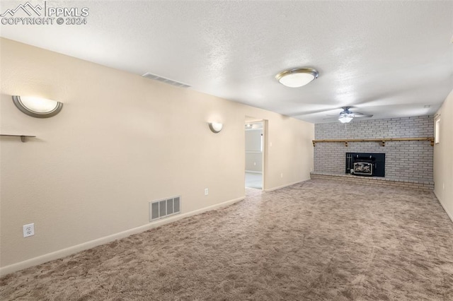 unfurnished living room featuring carpet, ceiling fan, and a wood stove