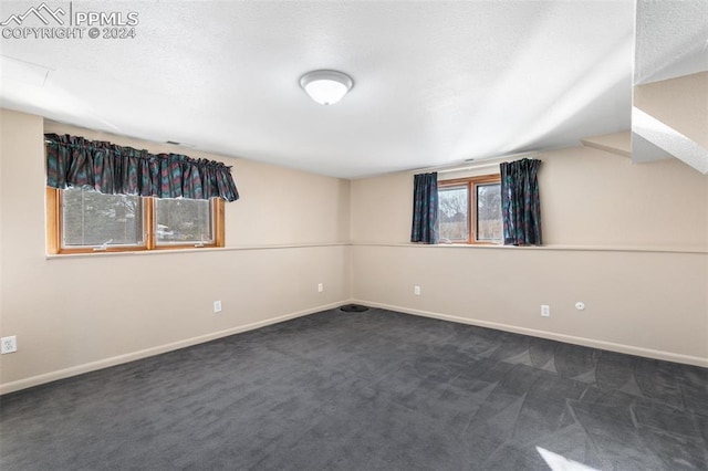 spare room with dark carpet