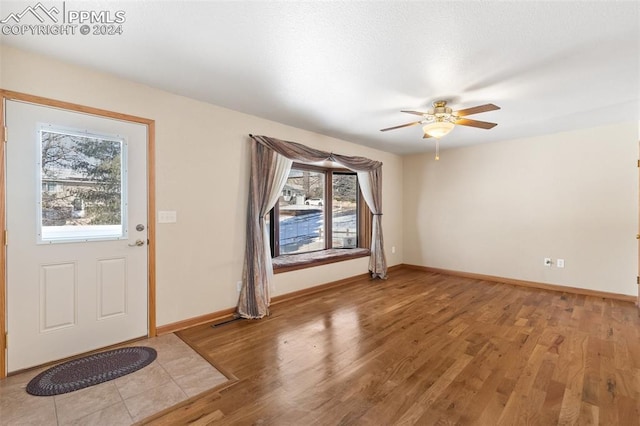 foyer with ceiling fan and light hardwood / wood-style floors