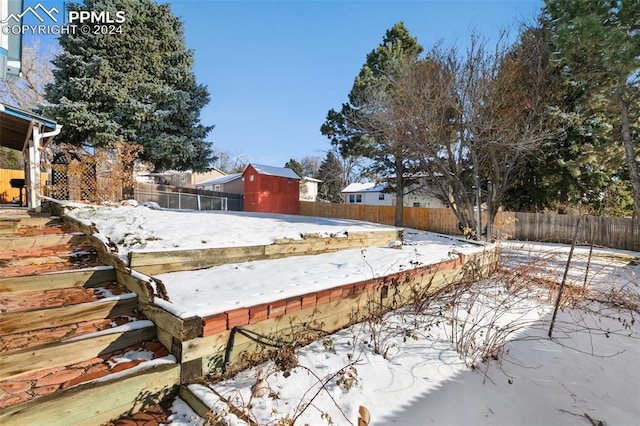 yard covered in snow with a storage unit