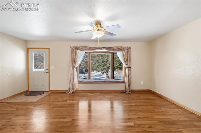 interior space with ceiling fan, hardwood / wood-style floors, and a textured ceiling