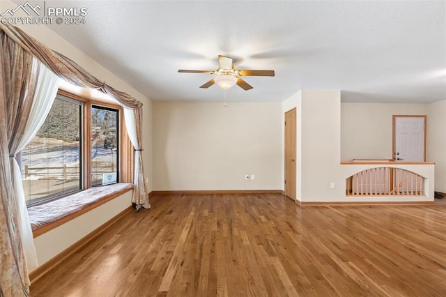 unfurnished living room with ceiling fan and wood-type flooring