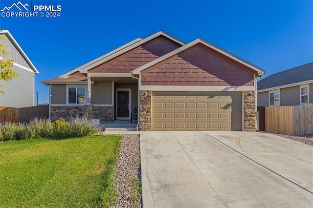 craftsman house with a garage and a front lawn