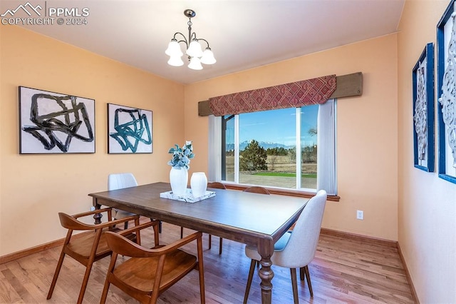 dining area featuring light hardwood / wood-style flooring and an inviting chandelier