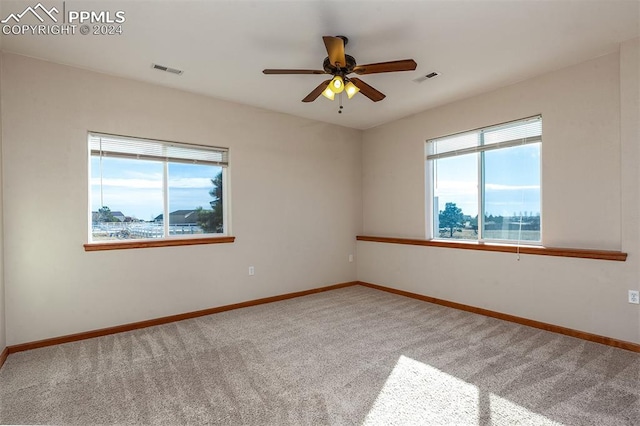 carpeted spare room featuring ceiling fan