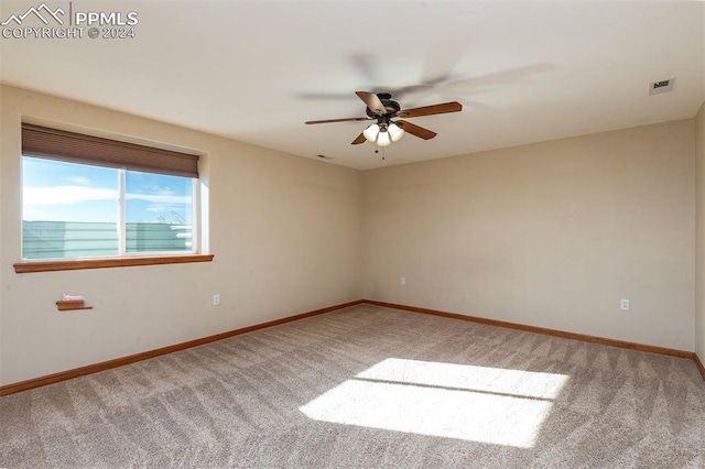 carpeted spare room featuring ceiling fan