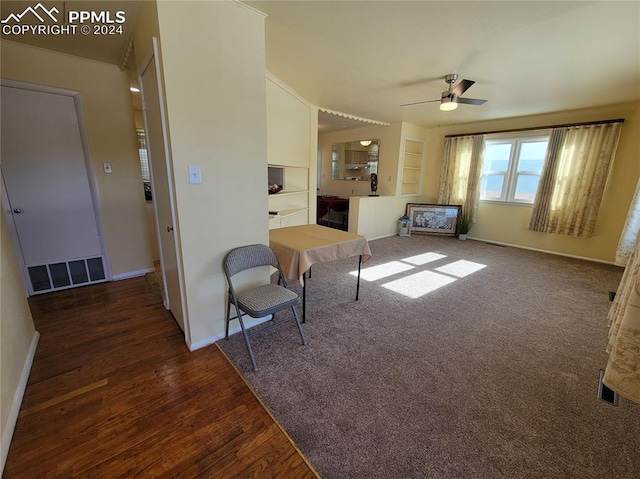 living room with ceiling fan and dark hardwood / wood-style floors