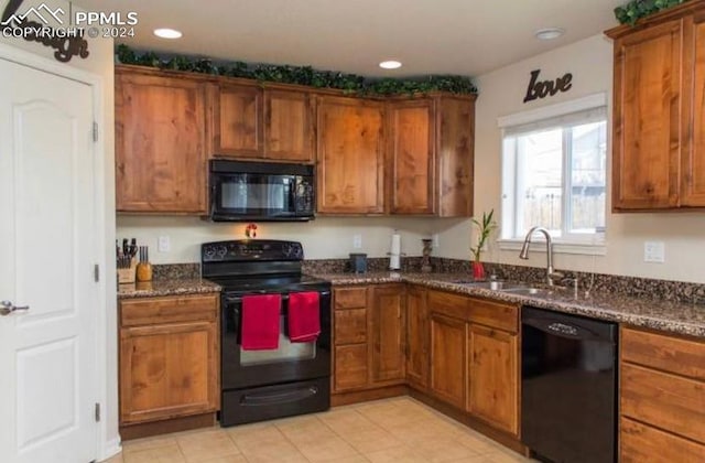 kitchen with sink, dark stone counters, and black appliances