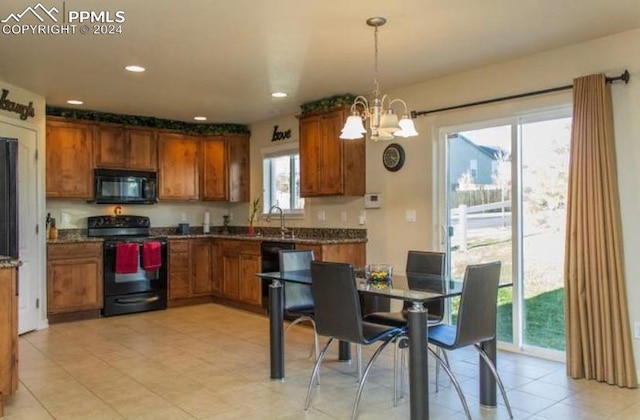 kitchen with sink, black appliances, pendant lighting, light tile patterned floors, and an inviting chandelier