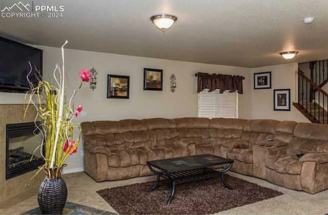 living room with a tiled fireplace and carpet floors