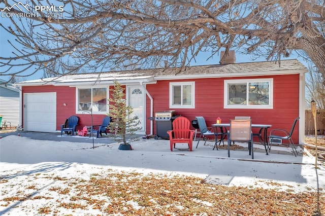 snow covered property with a garage