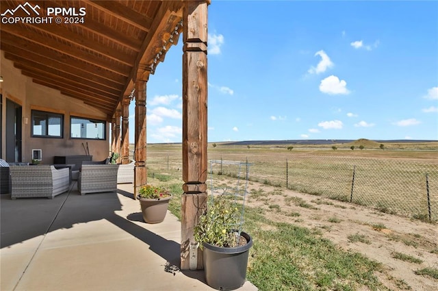 view of yard with outdoor lounge area, a rural view, and a patio area