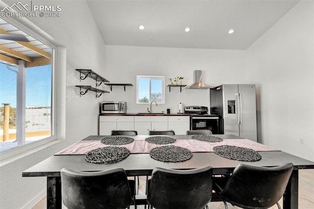 kitchen featuring white cabinets, sink, stainless steel appliances, and wall chimney range hood