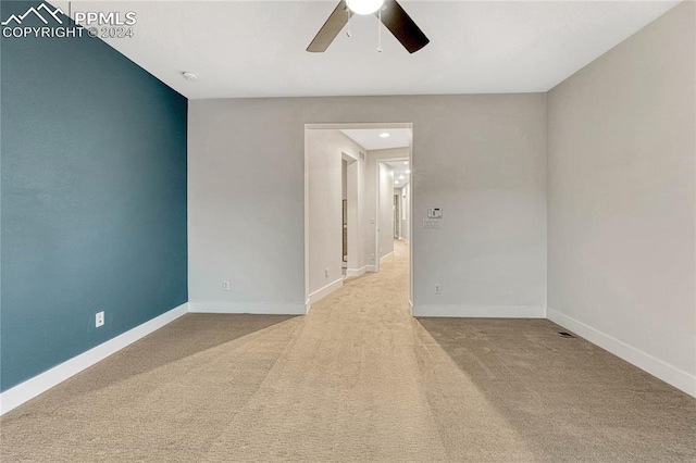 carpeted spare room featuring ceiling fan