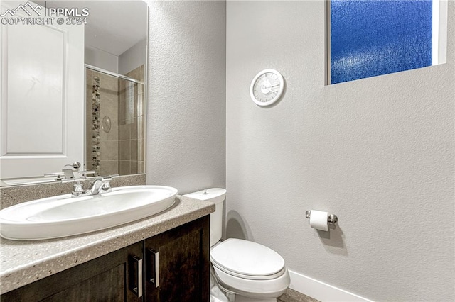 bathroom featuring vanity, toilet, and tiled shower