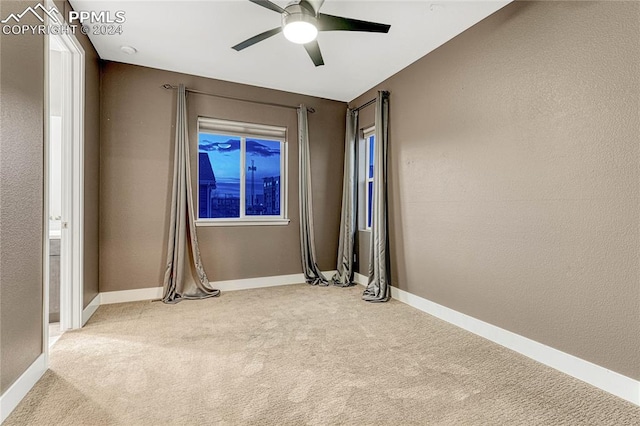 spare room with light carpet and ceiling fan