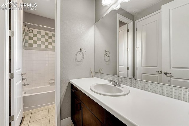 bathroom featuring tile patterned flooring, tiled shower / bath combo, and vanity