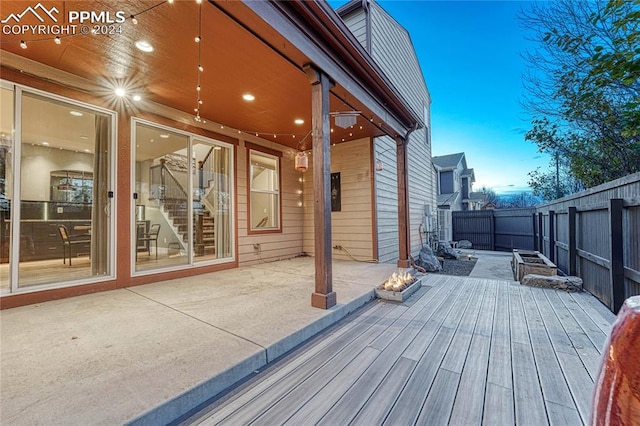 deck at dusk featuring a patio area