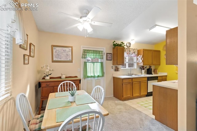 kitchen with ceiling fan, dishwasher, light colored carpet, and a textured ceiling