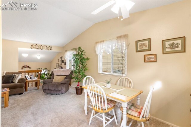 carpeted dining room with ceiling fan and lofted ceiling