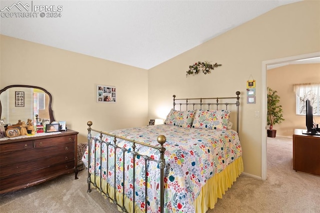 bedroom with light colored carpet and lofted ceiling