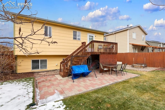 rear view of house featuring a lawn, a patio area, a deck, and an outdoor fire pit