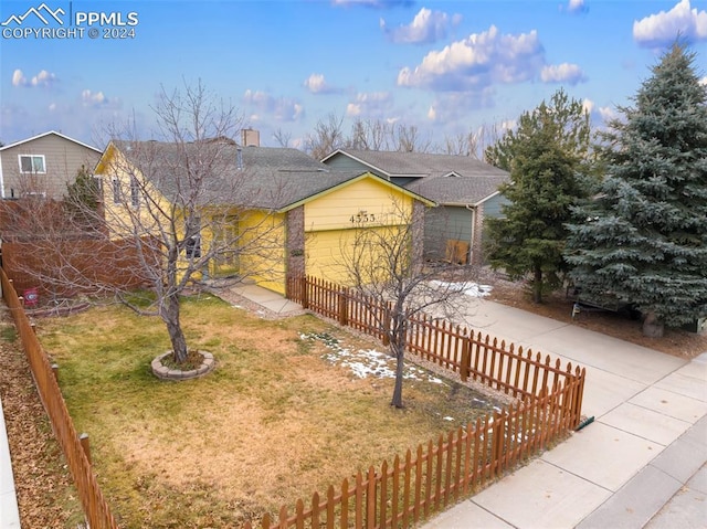 ranch-style house with a garage and a front lawn