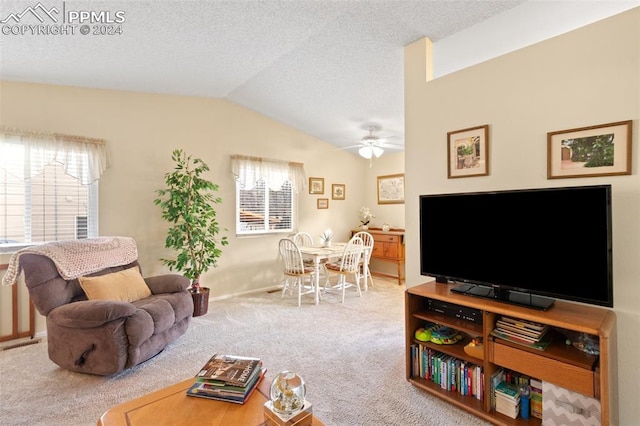 carpeted living room with ceiling fan and vaulted ceiling