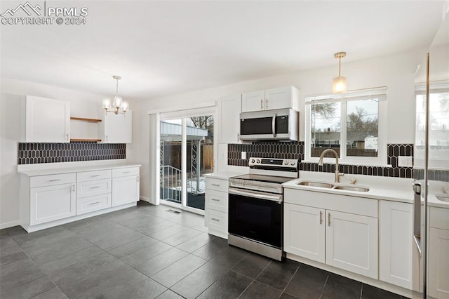 kitchen featuring white cabinets, backsplash, hanging light fixtures, and electric stove