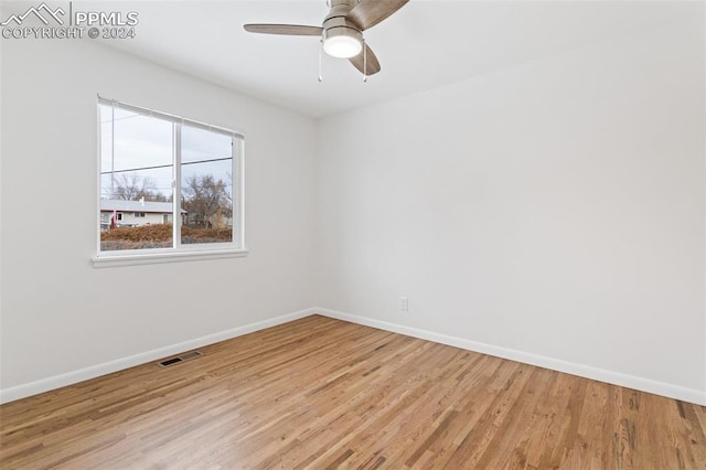 empty room with ceiling fan and light hardwood / wood-style floors