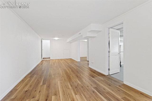 basement featuring light hardwood / wood-style flooring and ornamental molding