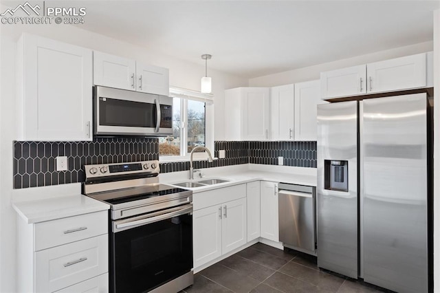 kitchen with white cabinets, decorative light fixtures, sink, and appliances with stainless steel finishes