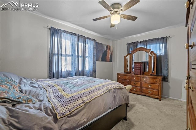 bedroom with ceiling fan, light carpet, and ornamental molding