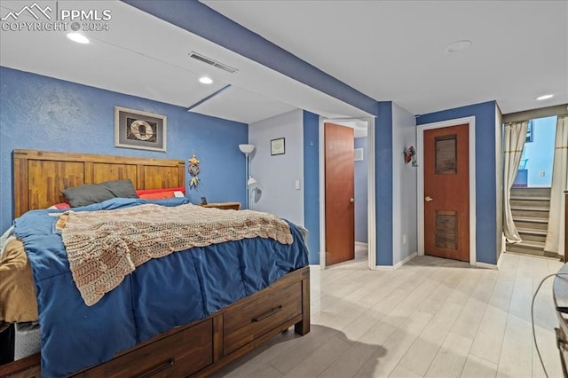 bedroom with light wood-type flooring and connected bathroom