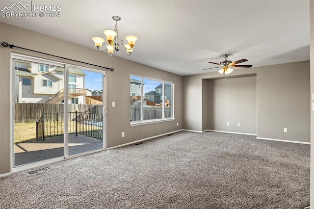 spare room featuring carpet and ceiling fan with notable chandelier