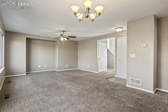 empty room with carpet and ceiling fan with notable chandelier