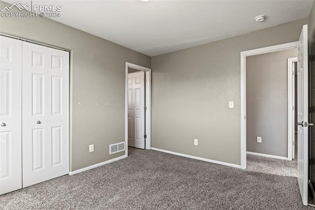 unfurnished bedroom featuring carpet flooring and a closet