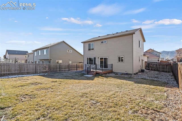 rear view of property with a yard and a deck