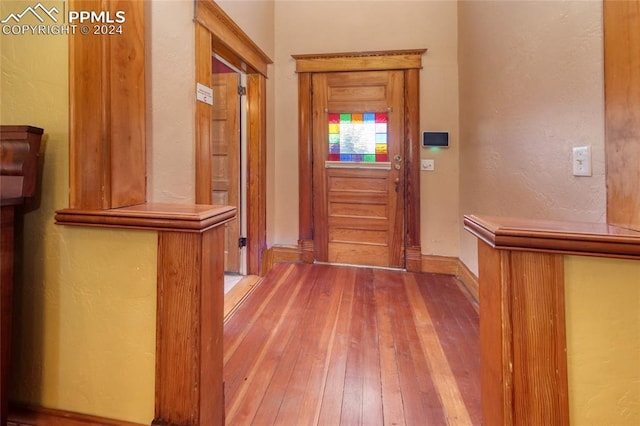 corridor with hardwood / wood-style flooring