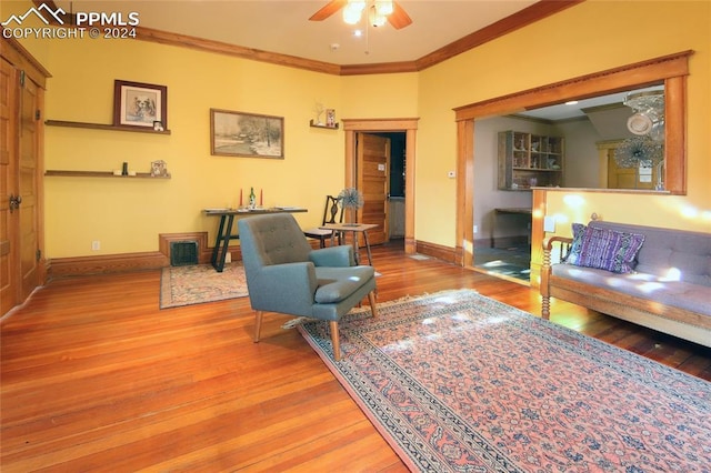 living room with hardwood / wood-style floors, ceiling fan, and crown molding