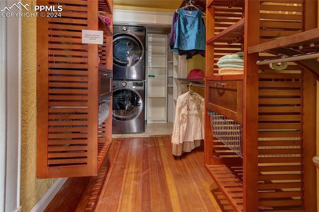 laundry area with stacked washing maching and dryer and wood-type flooring