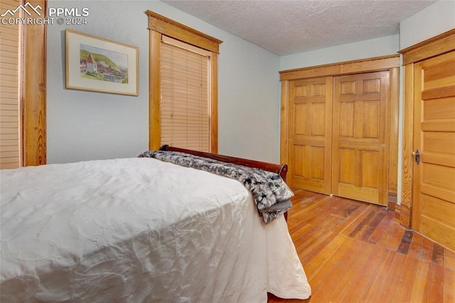 bedroom featuring a textured ceiling and hardwood / wood-style flooring