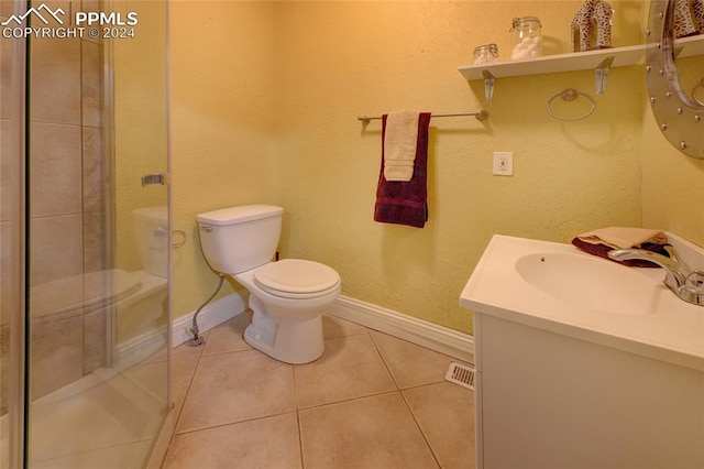 bathroom with tile patterned flooring, vanity, a shower with door, and toilet