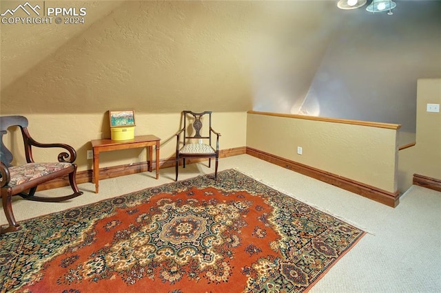 living area featuring carpet flooring and vaulted ceiling