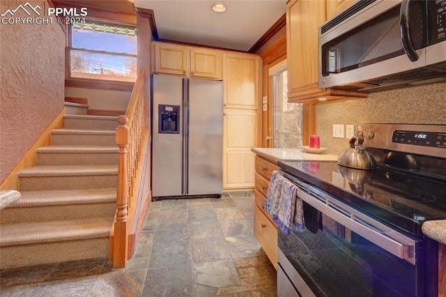 kitchen featuring light brown cabinetry, stainless steel appliances, and ornamental molding