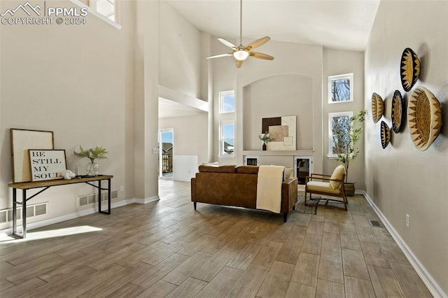 living room with hardwood / wood-style flooring, high vaulted ceiling, and ceiling fan