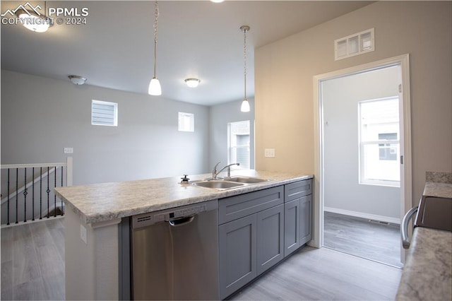 kitchen featuring a wealth of natural light, sink, stainless steel dishwasher, and light wood-type flooring