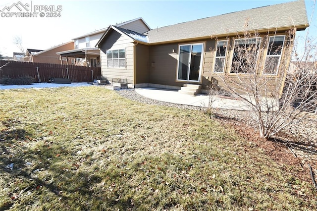 back of property with a lawn and a patio